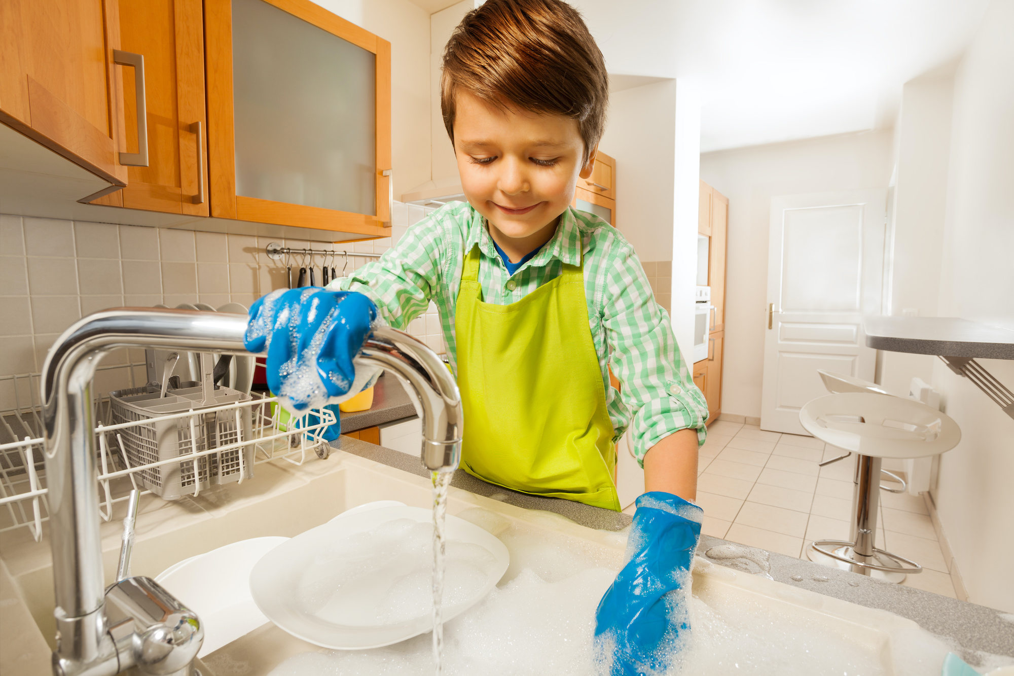 Ребенок помогает по дому. Полоскание посуды. Мальчик моет обувь. Мальчик моет посуду
